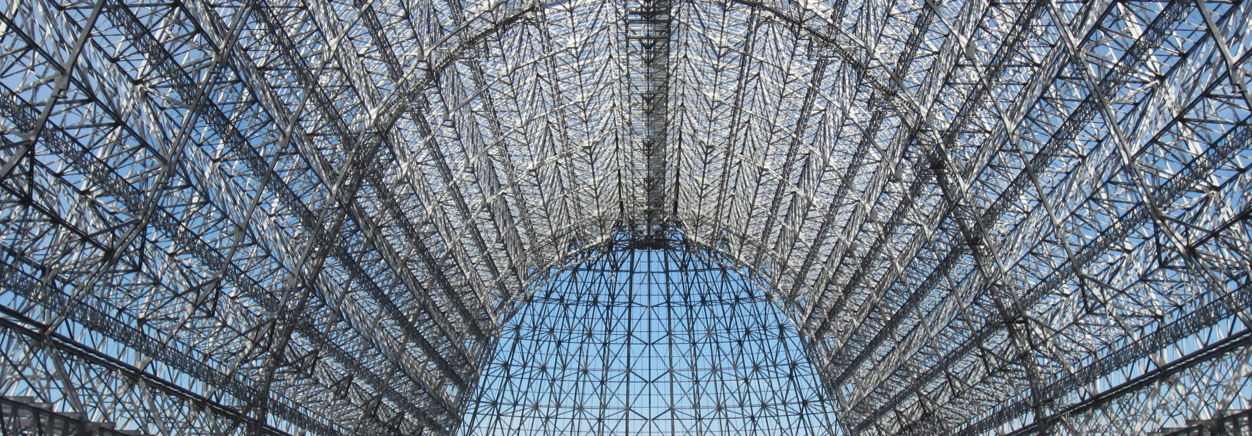 Metal frame of dirigible hanger against blue sky